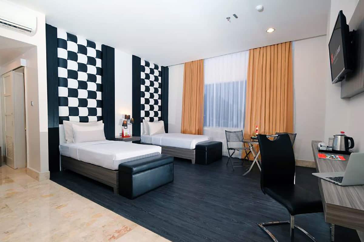Una habitación de hotel moderna con dos camas, un escritorio, una silla y un televisor.