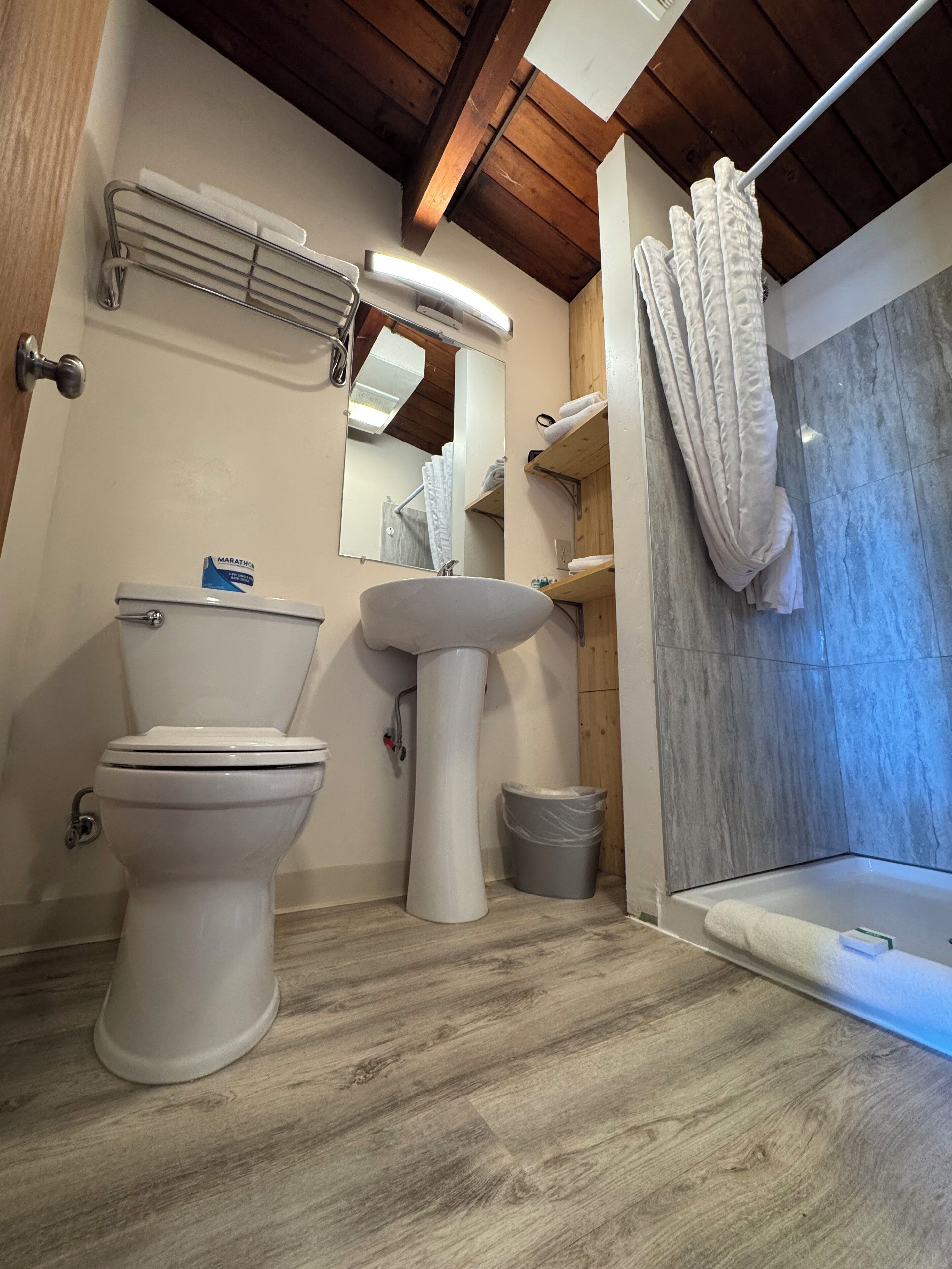 Ein modernes Badezimmer mit Toilette, Waschtisch und Dusche.