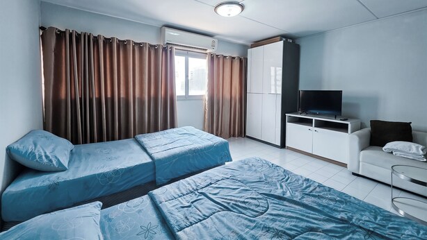 A bedroom with two beds, a wardrobe, a TV, and a desk. - Muangthong Inn (Pak Kret)
