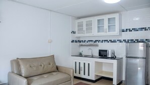 A kitchenette with a microwave, toaster, and refrigerator. - Muangthong Inn (Pak Kret)