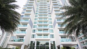 A modern high-rise building with multiple balconies, large windows, and a central entrance. - The View Cosy Beach by PSR ASIA (Pattaya)