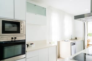 Una cocina moderna con electrodomésticos integrados, una encimera y vistas al exterior.