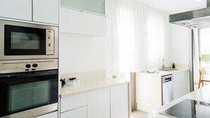 Una cuina moderna amb electrodomèstics integrats, un taulell i vista cap a l'exterior.