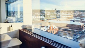 A modern bathroom with a large window overlooking a cityscape. - U&Me, BW Signature Collection (Umea)