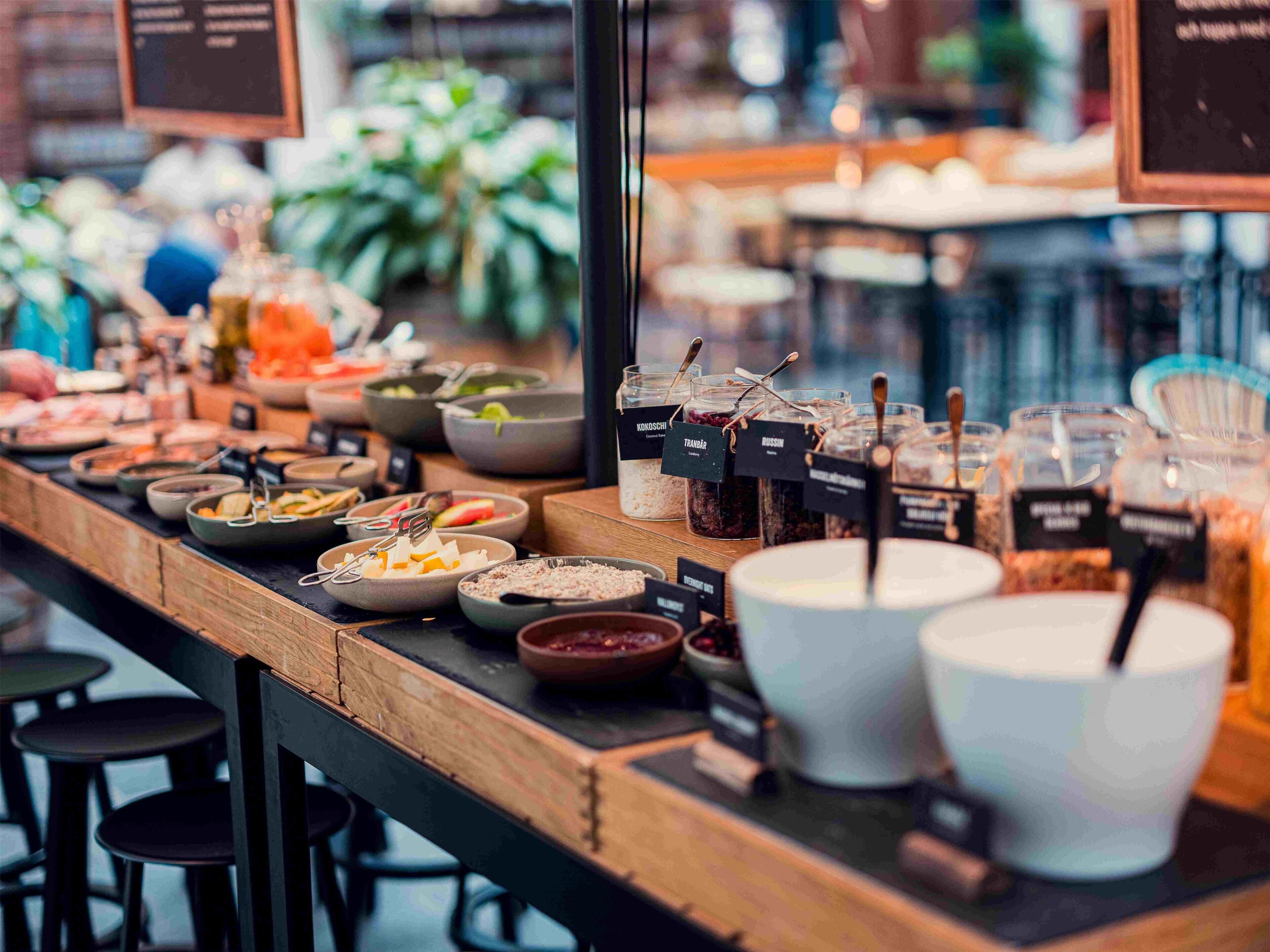 A buffet setup with various food containers and utensils.