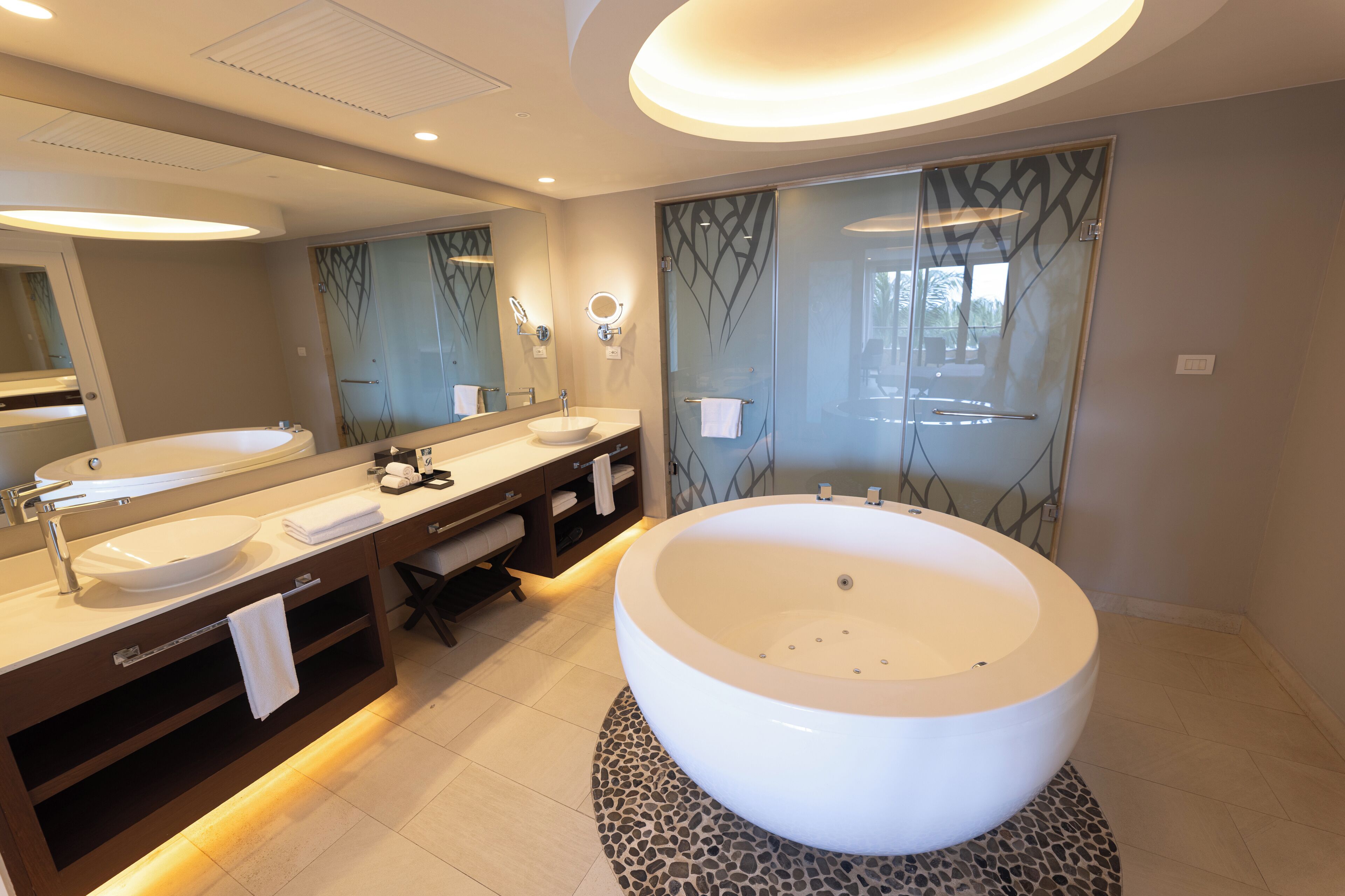 Une salle de bain moderne dotée d’une grande baignoire sur pieds, d’un meuble-lavabo double avec un vasque et d’une douche à parois de verre.