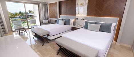 A hotel room with two beds, a balcony, and a view of the ocean.