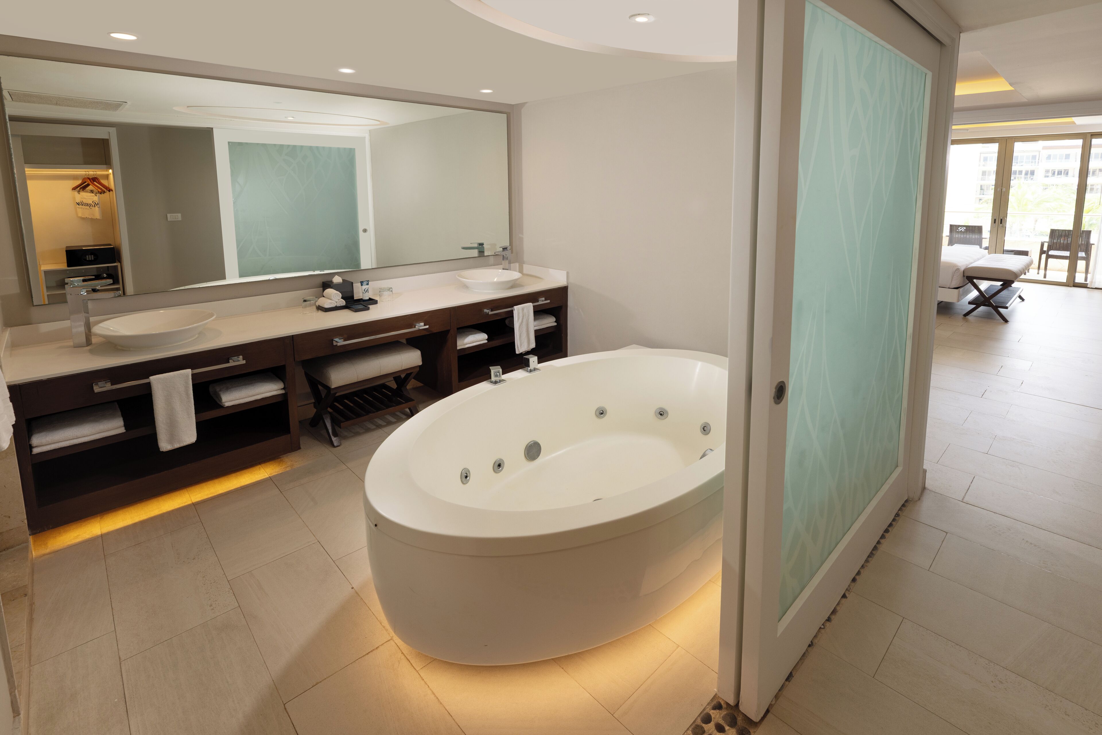 A modern bathroom with a freestanding bathtub, a large mirror, and a vanity with a sink.