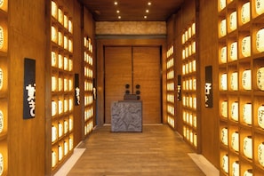 A hallway with wooden walls and a reception desk at the end.