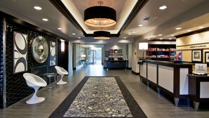 A hotel lobby with a reception desk, seating area, and a chandelier. - Hampton Inn & Suites Bellevue Downtown-Seattle (Bellevue)