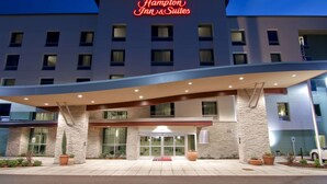 A Hampton Inn & Suites hotel with a modern facade, large windows, and a prominent neon sign. - Hampton Inn & Suites Bellevue Downtown-Seattle (Bellevue)