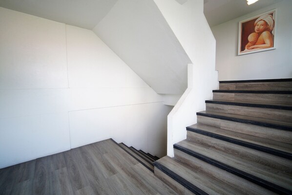 A staircase with wooden steps and white walls. -  Wild Orchid Villa Bangkok (Bangkok)