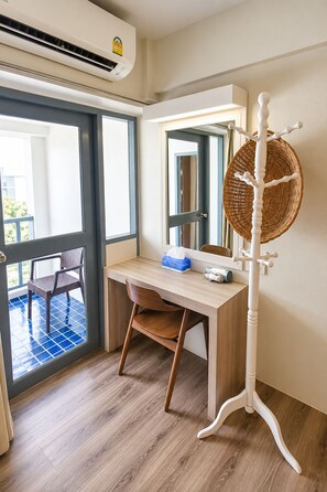 A room with a desk, chair, and a wall-mounted mirror. -  Wild Orchid Villa Bangkok (Bangkok)