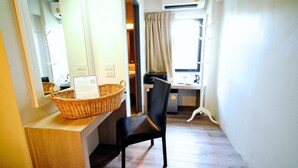 A small room with a desk, a chair, a wicker basket, and a window with curtains. -  Wild Orchid Villa Bangkok (Bangkok)