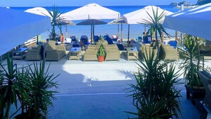 A beachside resort with outdoor seating areas, umbrellas, and potted plants. - Blue Sea Beach Resort (Thasos)