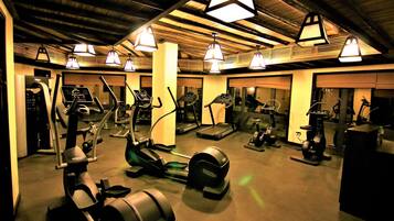 A gym with treadmills, elliptical machines, and stationary bikes.