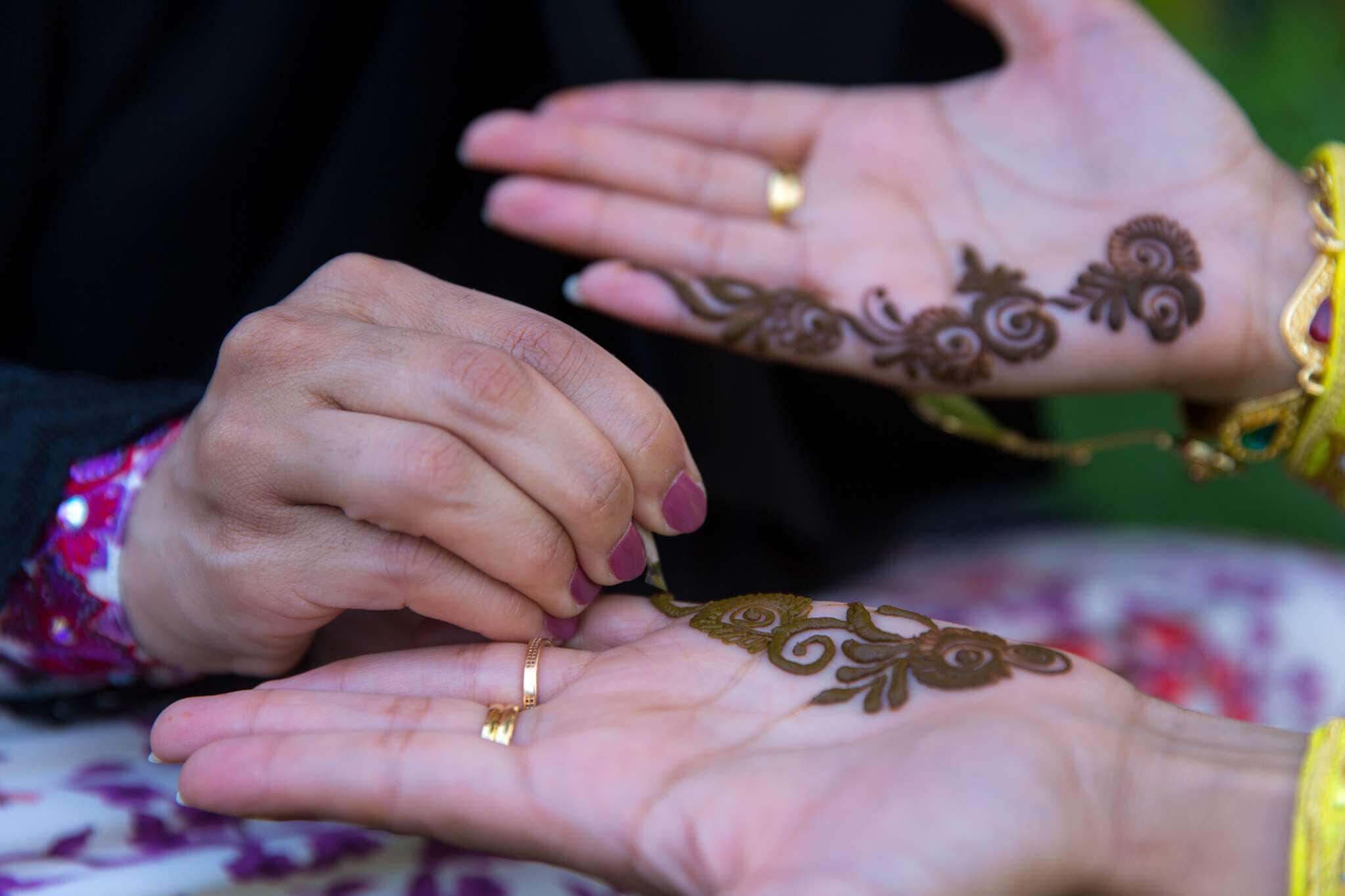 A close-up of hands with henna designs.