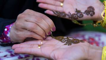 A close-up of hands with henna designs.