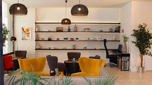 A modern interior with a sofa, chairs, a desk, shelves with decorative items, and pendant lighting. - Tempo Fair Suites (Istanbul)