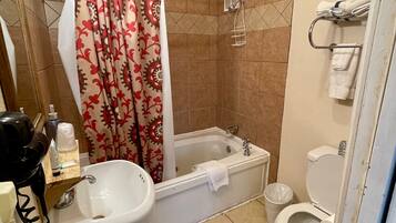 Une salle de bain avec une baignoire, des toilettes et un lavabo.