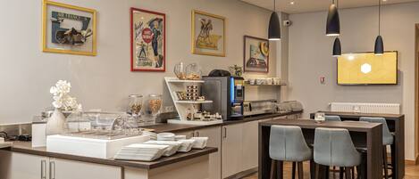Una cocina moderna con una isla central, taburetes de bar y un televisor de pantalla plana en la pared.