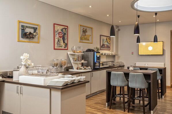 Une cuisine moderne dotée d’un îlot central, de tabourets de bar et d’un téléviseur à écran plat fixé au mur.