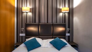 A modern hotel room with a large bed, two bedside lamps, and a striped wall. - Hôtel d'Orléans (Orléans)