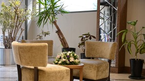 A room with two beige armchairs, a small wooden table, and several potted plants. - Style Hotel Sisli (Istanbul)