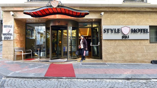 A hotel entrance with a revolving door, a red carpet, and a sign indicating 'STYLE HOTEL'. - Style Hotel Sisli (Istanbul)
