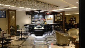 A modern bar area with a checkered floor, bar stools, and a glass display case. - Style Hotel Sisli (Istanbul)