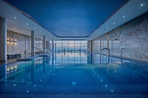 Una piscina techada, sillones reclinables de piscina