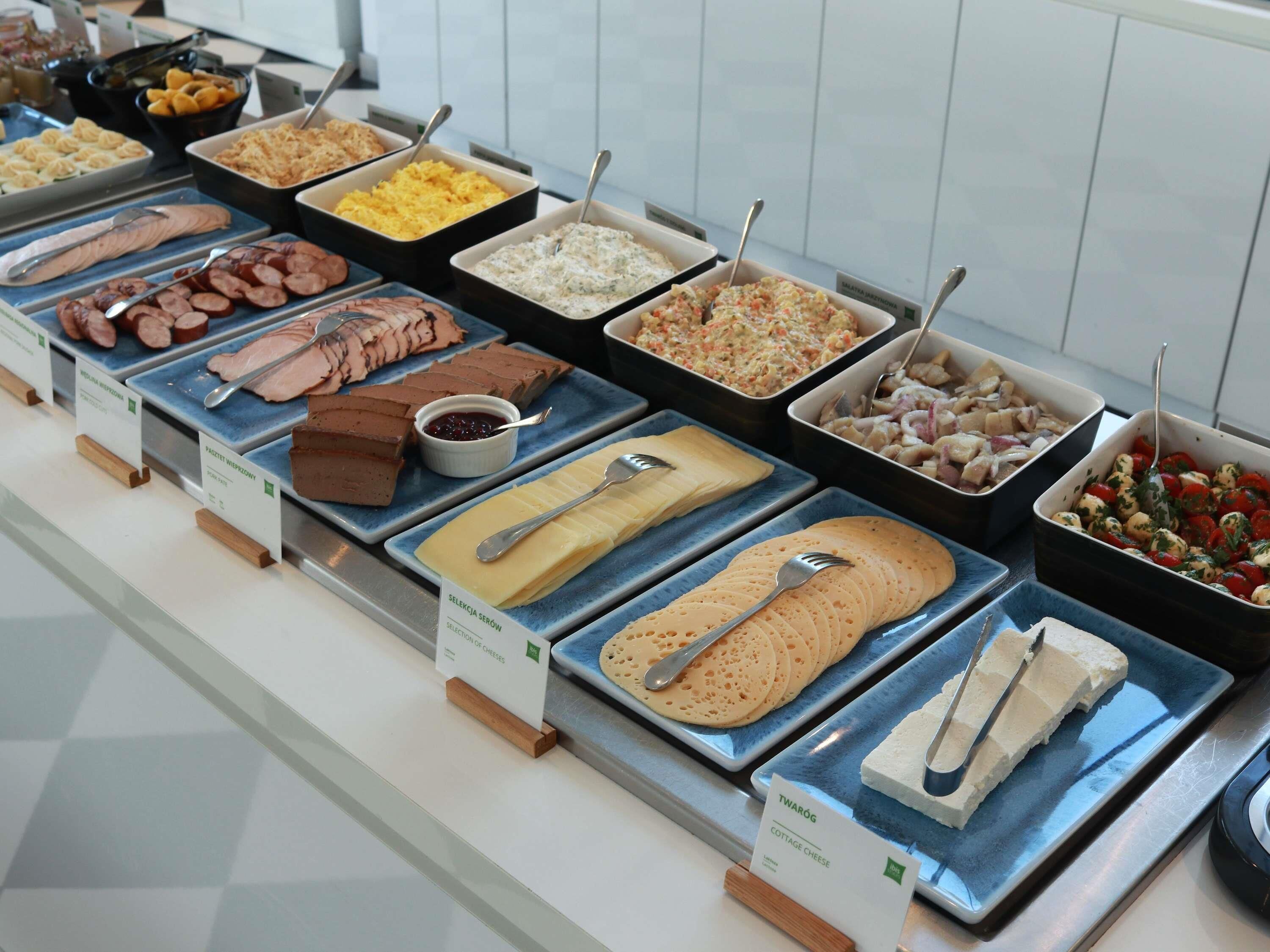 Un bufé con diferentes opciones de comida, como carnes, quesos y ensaladas.