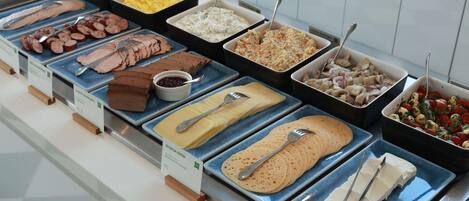 Un bufé con diferentes opciones de comida, como carnes, quesos y ensaladas.