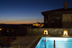Una piscina al aire libre, sombrillas, sillones reclinables de piscina