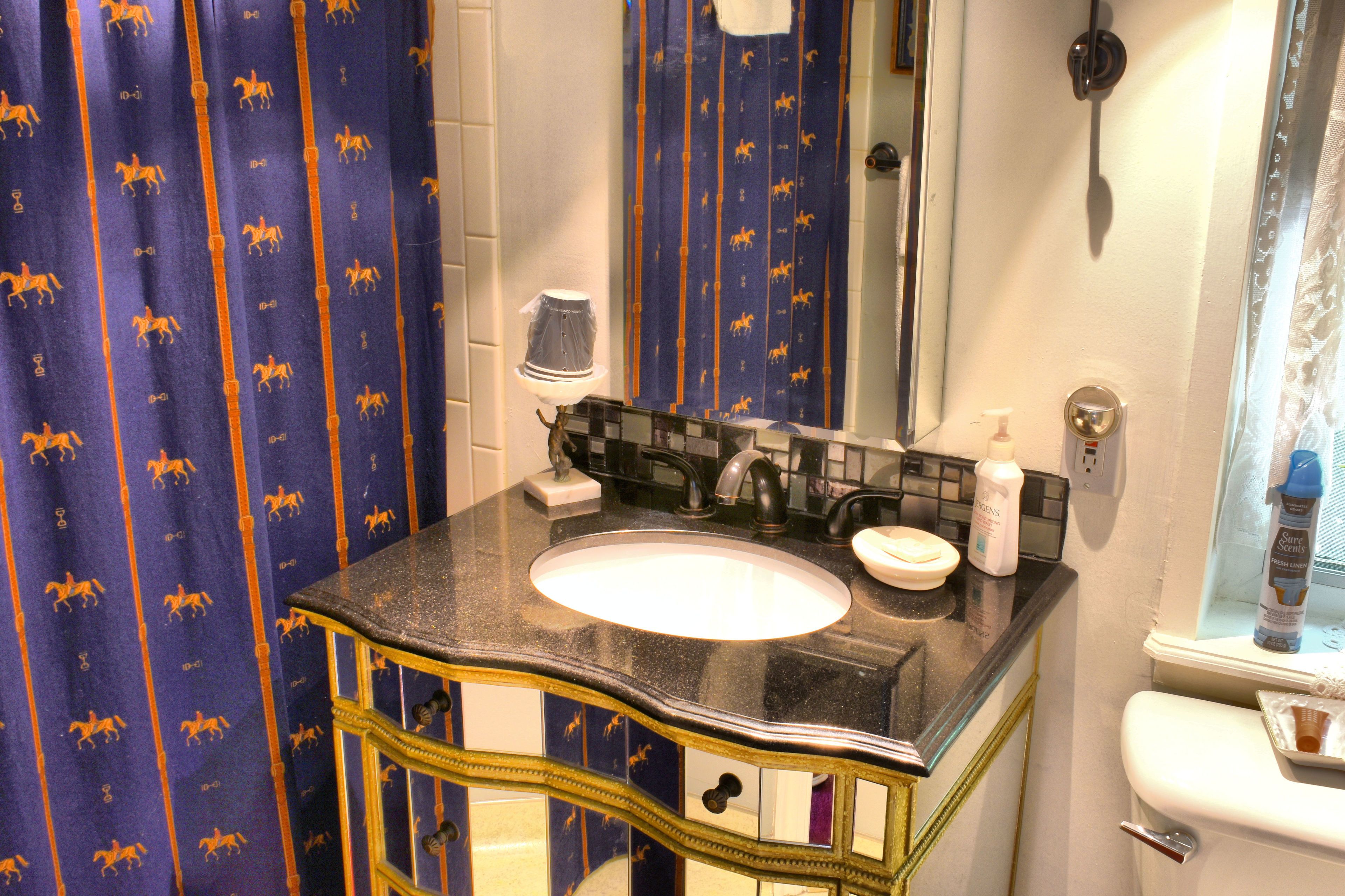 A bathroom with a sink, mirror, and toilet.