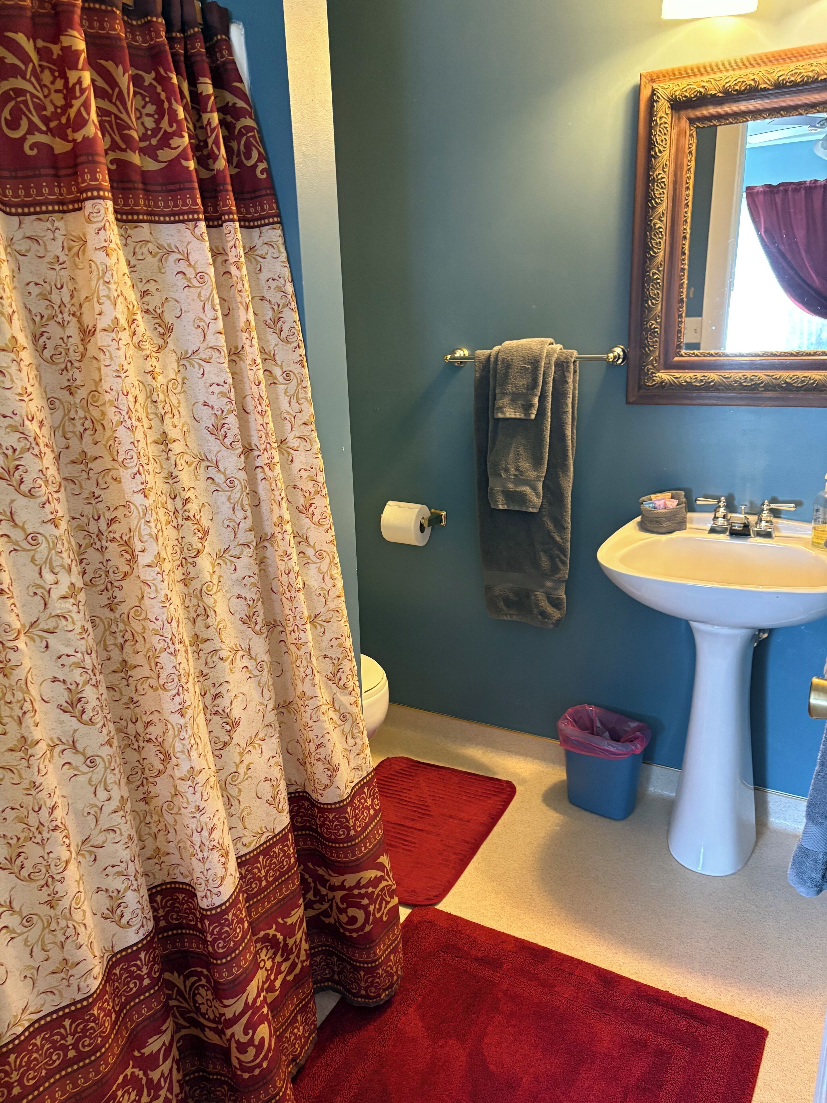 Une salle de bain équipée de toilettes, d’un lavabo et d’un rideau de douche.