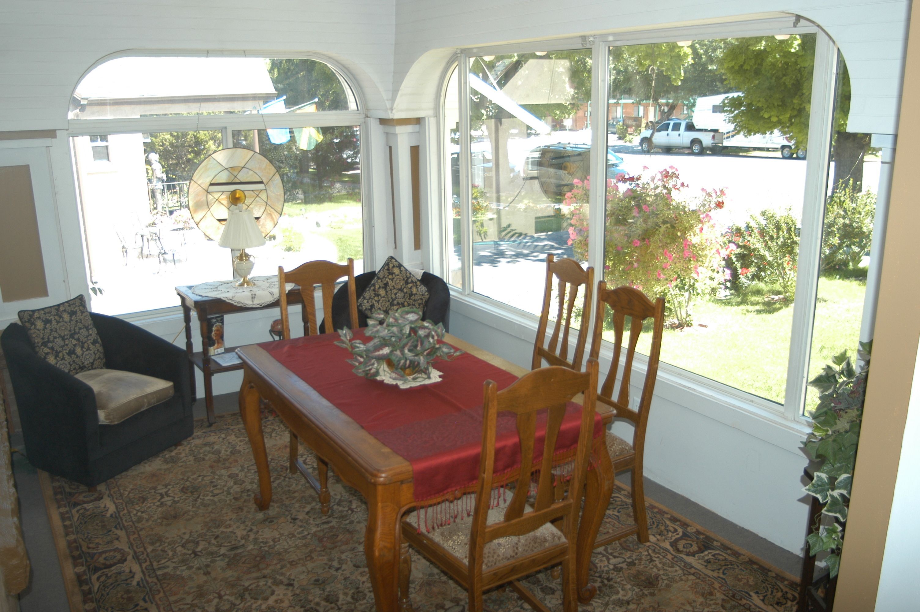 A dining area with a table set for four, a sofa, and a window with a view of the street.