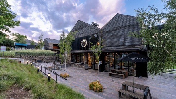 A modern building with a large glass facade and outdoor seating area. - Peppers Marysville (Marysville)
