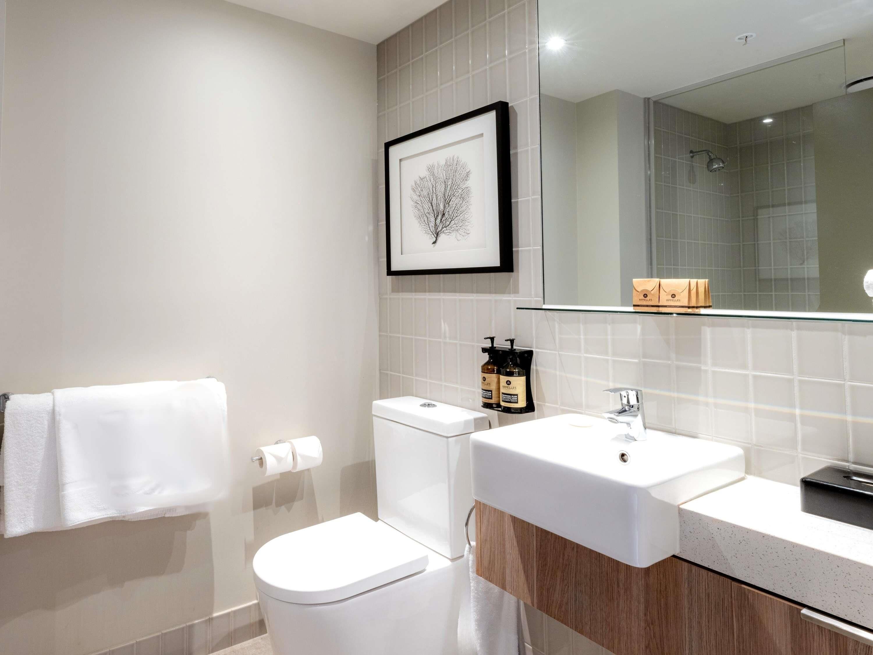 Un baño moderno con inodoro, lavabo y ducha.