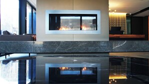 A modern interior with a fireplace, marble countertops, and a reflective floor. - Peppers Marysville (Marysville)