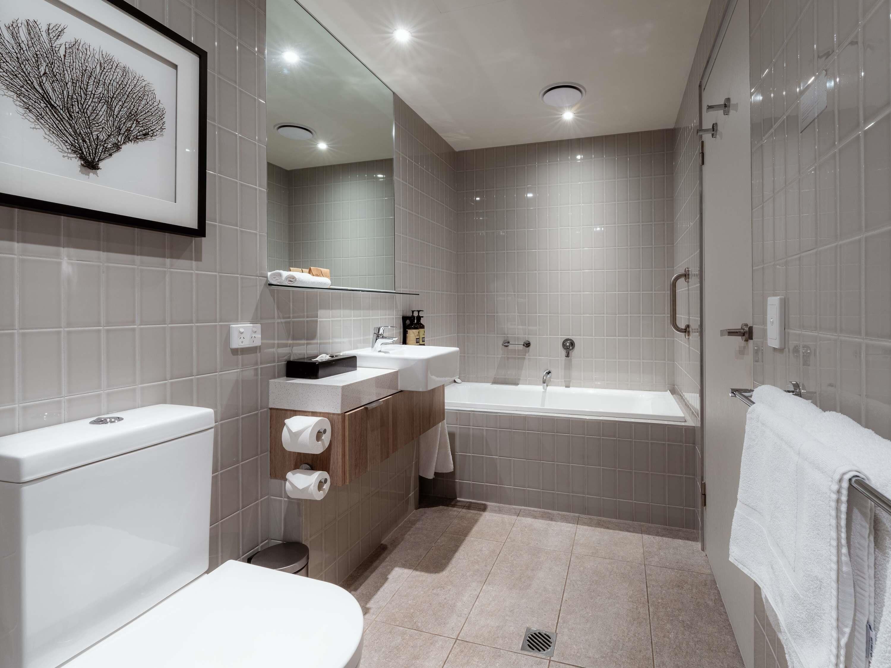 Un baño moderno con inodoro, lavamanos y bañera.
