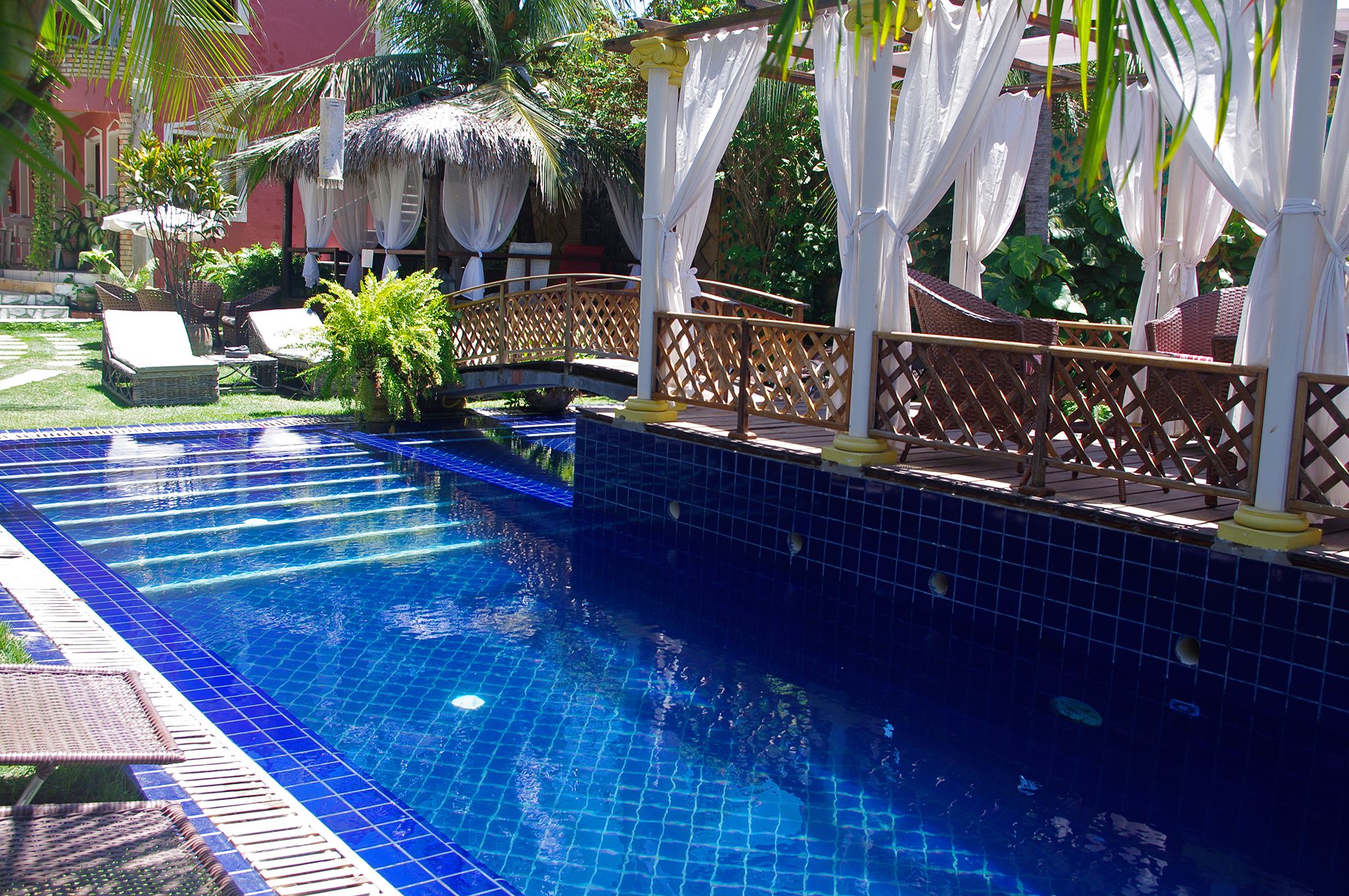 Una piscina al aire libre, sillones reclinables de piscina