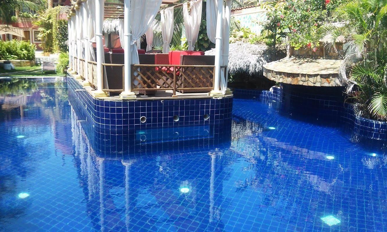 Una piscina al aire libre, sillones reclinables de piscina