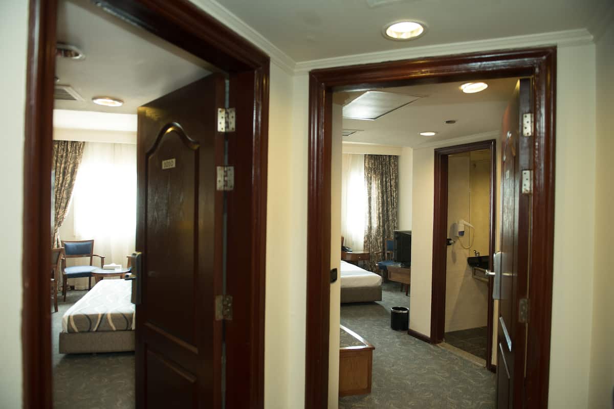 A hotel room with a bed, a chair, a desk, and a bathroom.