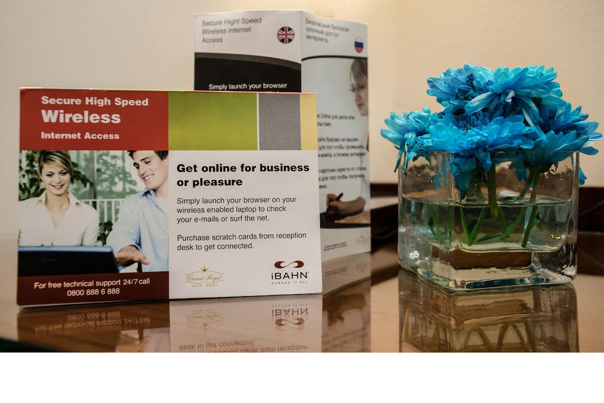 A hotel brochure and a vase with flowers on a table.