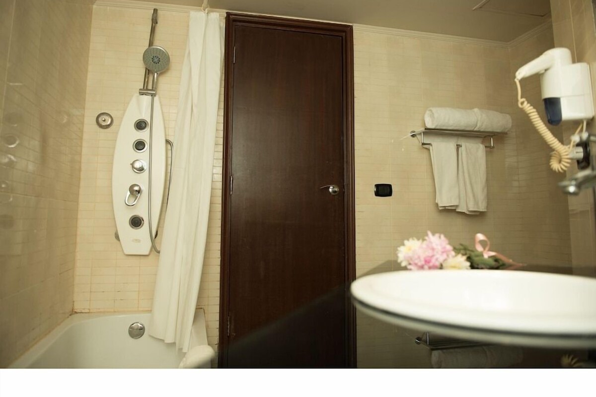 A bathroom with a bathtub, a shower, a toilet, and a sink.