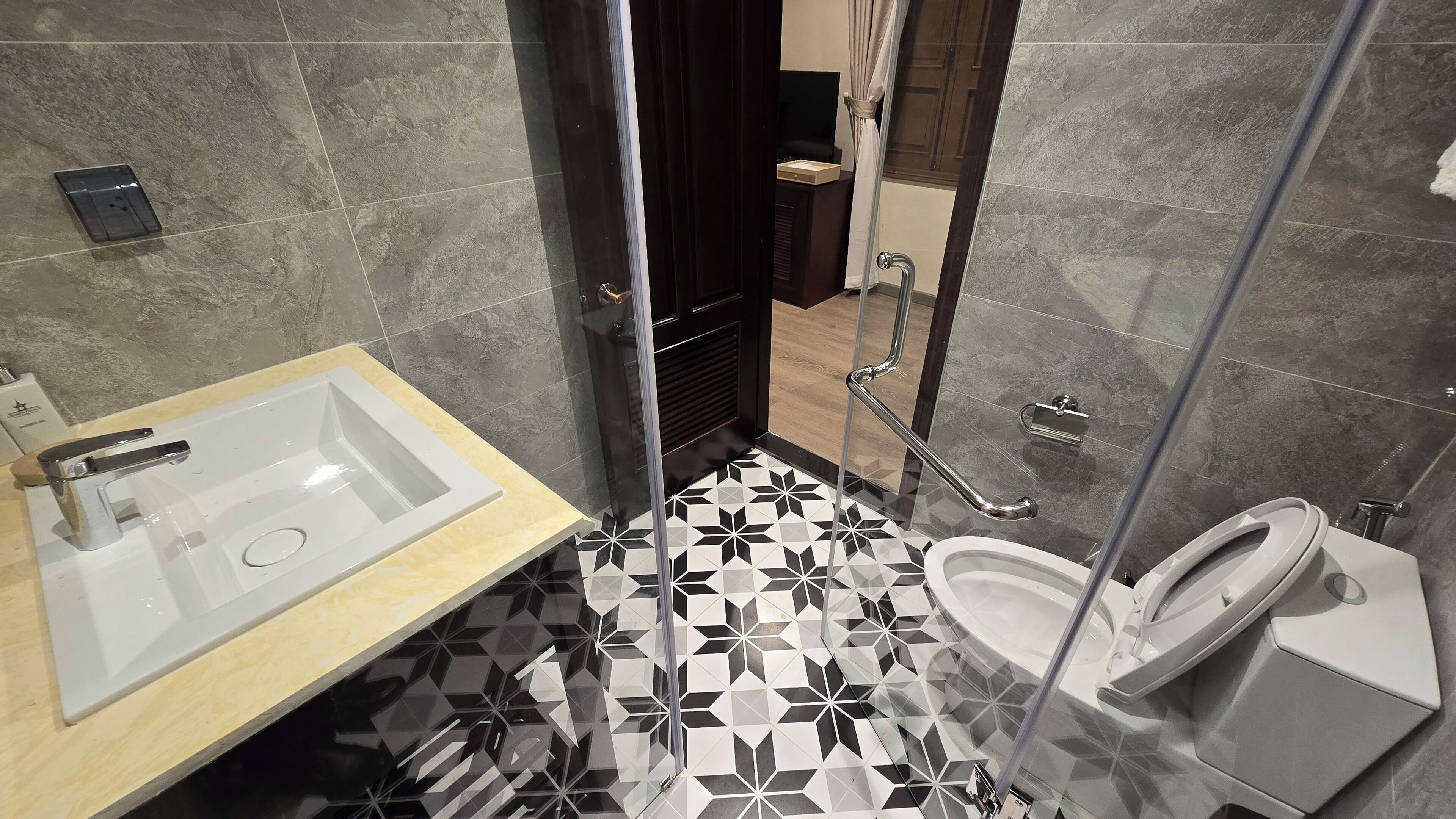 A modern bathroom with a white sink, a toilet, and a shower area.