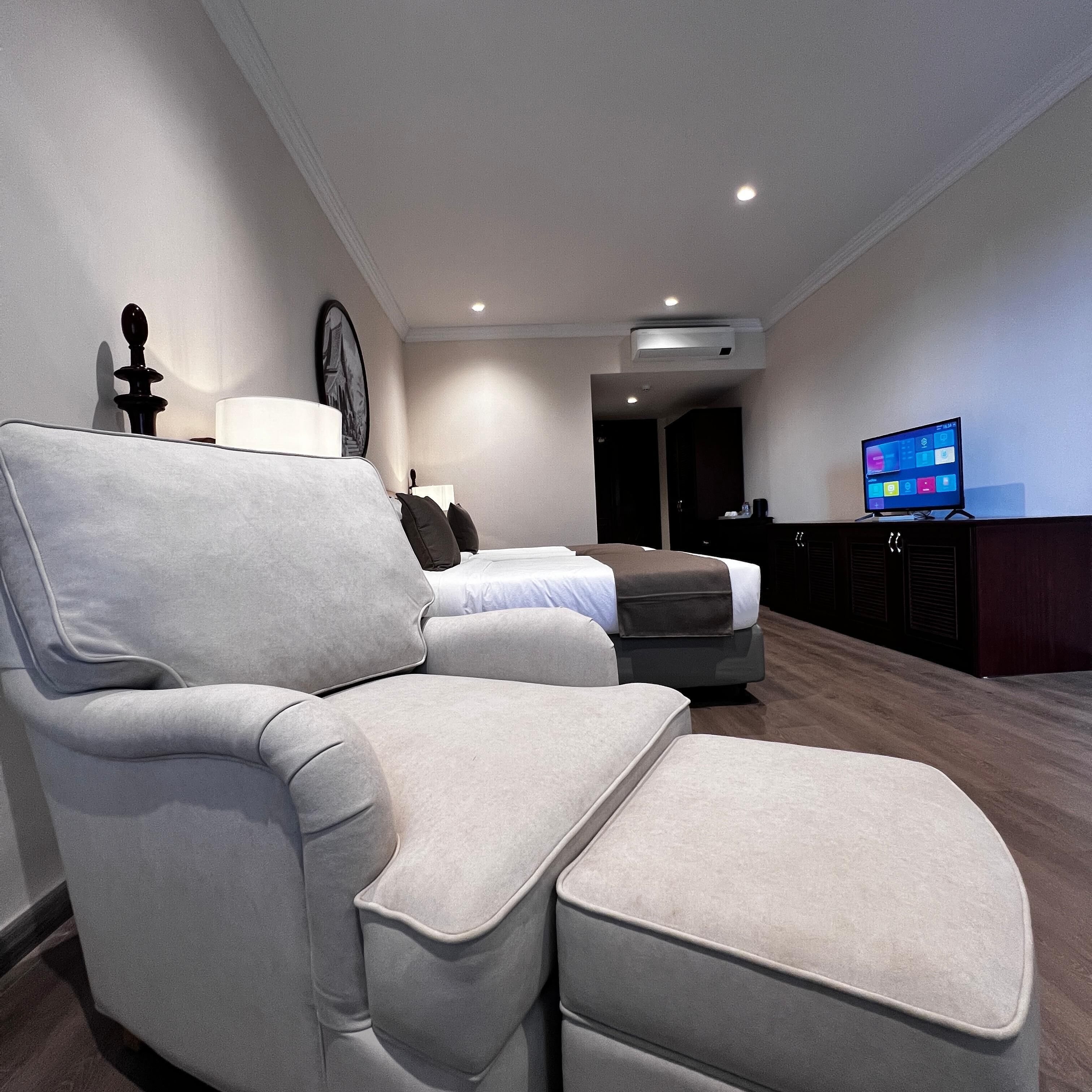 A modern living room with a sectional sofa, a flat-screen TV, and a minimalist decor.