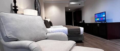 A modern living room with a sectional sofa, a flat-screen TV, and a minimalist decor.