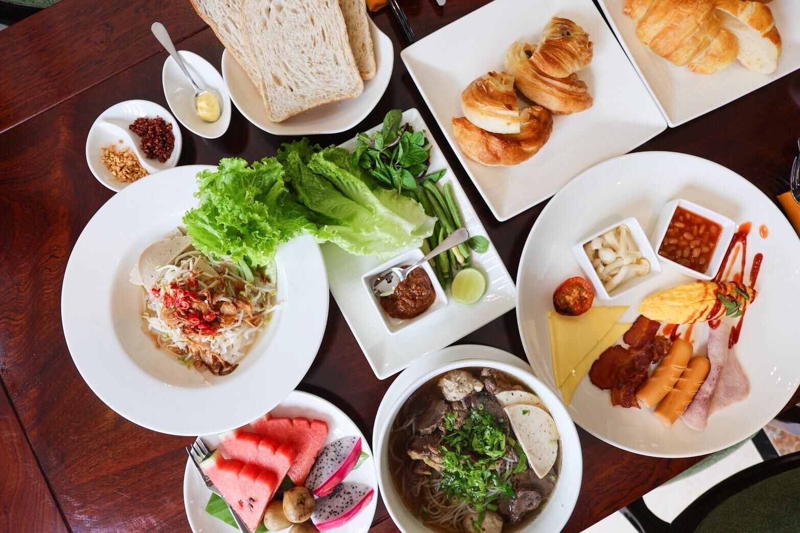 A table with various dishes including bread, salad, soup, and meat.